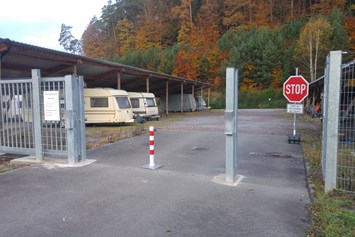 Einstellplatz: Absperrbake zur Zufahrtskontrolle, Überwachungskamera oben links im Bild ersichtlich - Einstellplätze im Solarpark Dahn bei Firma Gethmann-Becker-Pötsch GbR